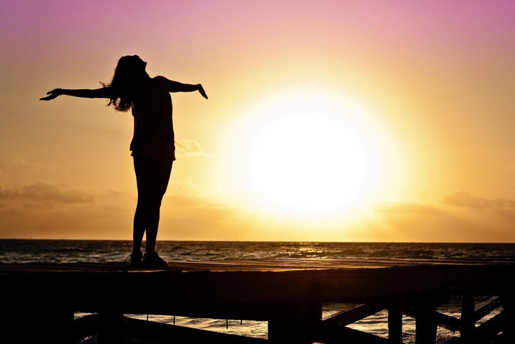 Frau am Strand vor Sonnenuntergang